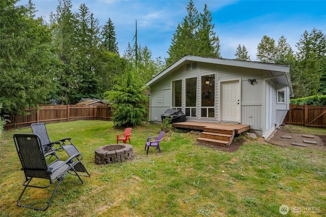 13020 W Loop View Dr, Granite Falls, WA 98252 - back of property with an outdoor fire pit, a fenced backyard, an outdoor structure, and a deck