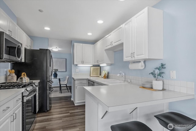 4714 Fairwood Blvd NE Unit 1301, Tacoma, WA 98422 - kitchen featuring stainless steel appliances, a peninsula, white cabinetry, light countertops, and a breakfast bar area