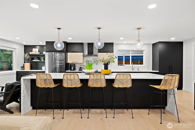 11171 SE 59th St, Bellevue, WA 98006 - kitchen with stainless steel refrigerator, wall chimney range hood, light countertops, dark cabinetry, and modern cabinets