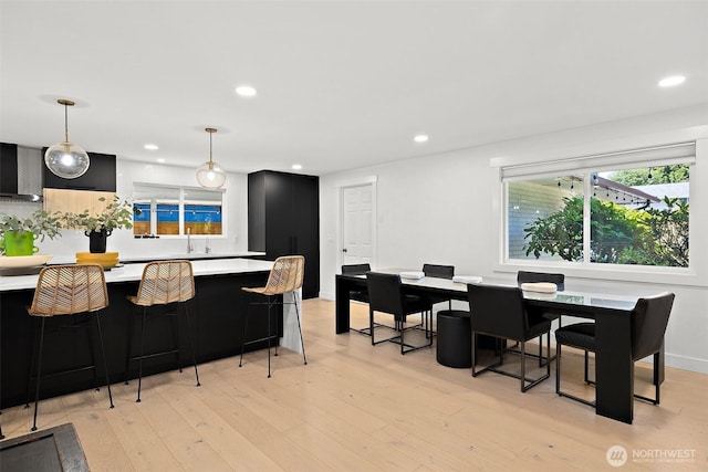 11171 SE 59th St, Bellevue, WA 98006 - kitchen featuring dark cabinets, light countertops, wall chimney range hood, recessed lighting, and light wood-style floors