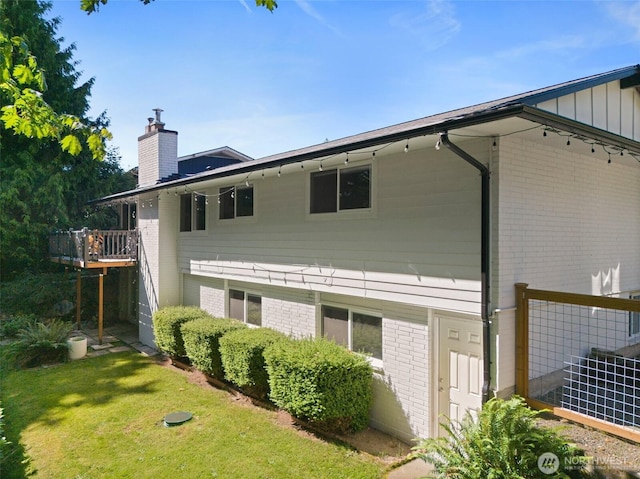 11171 SE 59th St, Bellevue, WA 98006 - back of house featuring a chimney, brick siding, and a lawn
