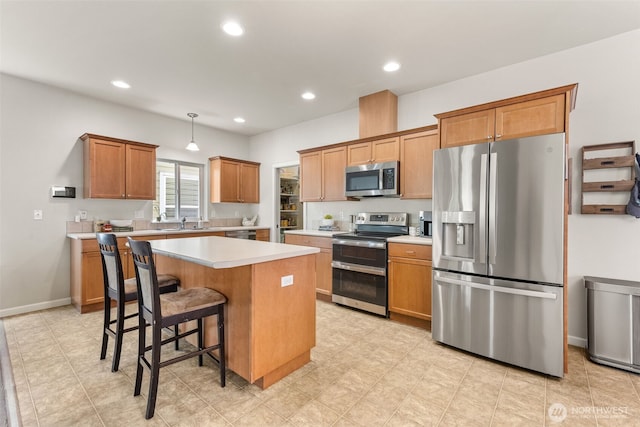 5611 Balustrade Blvd SE, Lacey, WA 98513 - kitchen with appliances with stainless steel finishes, light countertops, a center island, recessed lighting, and a kitchen bar
