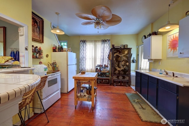 218 SW 15th St, Long Beach, WA 98631 - kitchen featuring white appliances, ceiling fan, pendant lighting, dark wood-style flooring, and tile counters