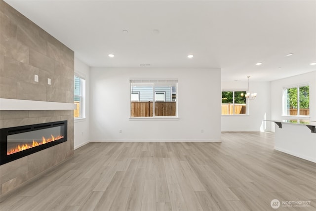 20420 97th Ave E Unit 5, Graham, WA 98338 - unfurnished living room featuring a tiled fireplace, light wood-type flooring, recessed lighting, and a chandelier