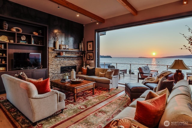 181 Utsalady Rd, Camano Island, WA 98282 - living area with wood finished floors, beam ceiling, a water view, a stone fireplace, and rail lighting