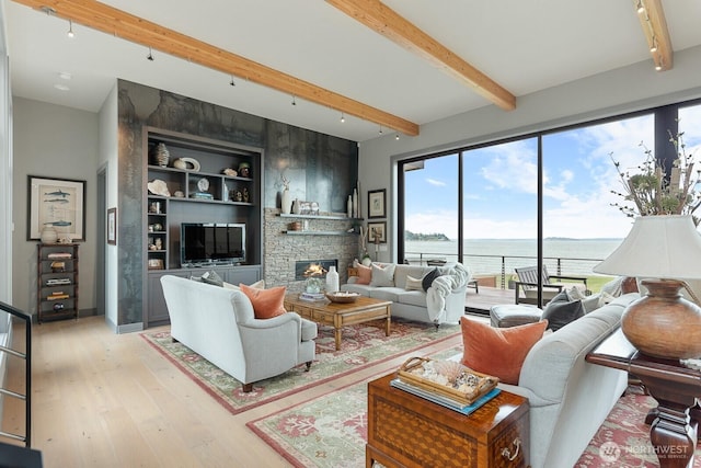 181 Utsalady Rd, Camano Island, WA 98282 - living room with beamed ceiling, light wood-type flooring, a fireplace, and track lighting