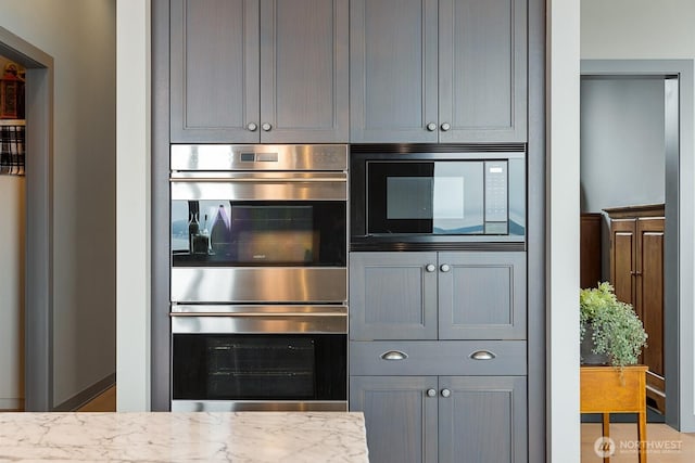 181 Utsalady Rd, Camano Island, WA 98282 - kitchen with stainless steel double oven, black microwave, gray cabinetry, and light stone countertops