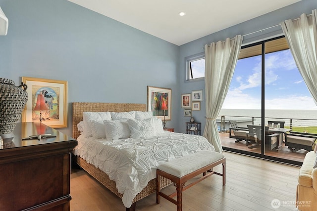 181 Utsalady Rd, Camano Island, WA 98282 - bedroom featuring access to exterior, a water view, recessed lighting, hardwood / wood-style floors, and a towering ceiling