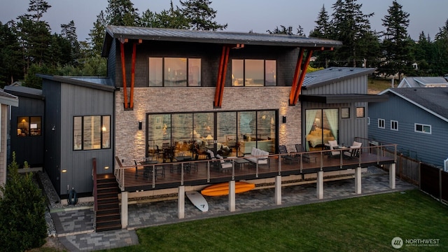 181 Utsalady Rd, Camano Island, WA 98282 - back of property featuring a wooden deck, a lawn, stone siding, and a metal roof