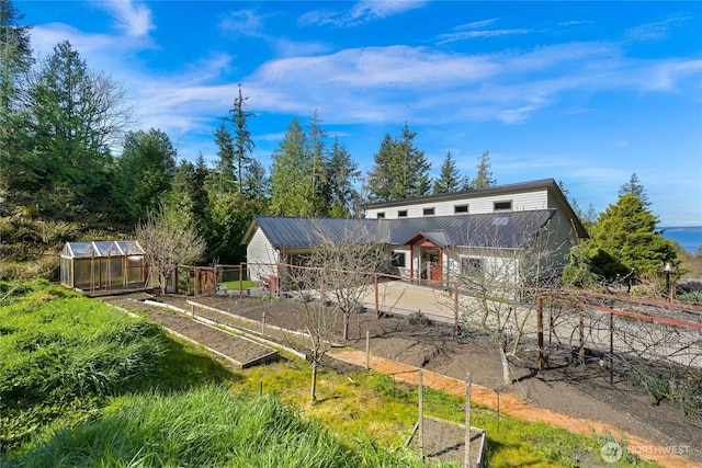 229 Chuckanut Point Rd, Bellingham, WA 98229 - back of property featuring a garden, an exterior structure, an outbuilding, and a metal roof