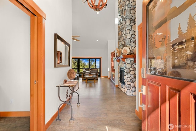 229 Chuckanut Point Rd, Bellingham, WA 98229 - entrance foyer with a stone fireplace, wood finished floors, a high ceiling, a chandelier, and a ceiling fan