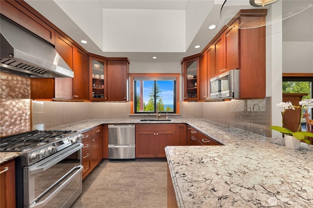 229 Chuckanut Point Rd, Bellingham, WA 98229 - kitchen featuring appliances with stainless steel finishes, ventilation hood, light stone countertops, tasteful backsplash, and brown cabinets