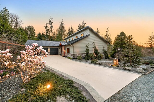 229 Chuckanut Point Rd, Bellingham, WA 98229 - view of front of property featuring stone siding, concrete driveway, a standing seam roof, a metal roof, and a garage