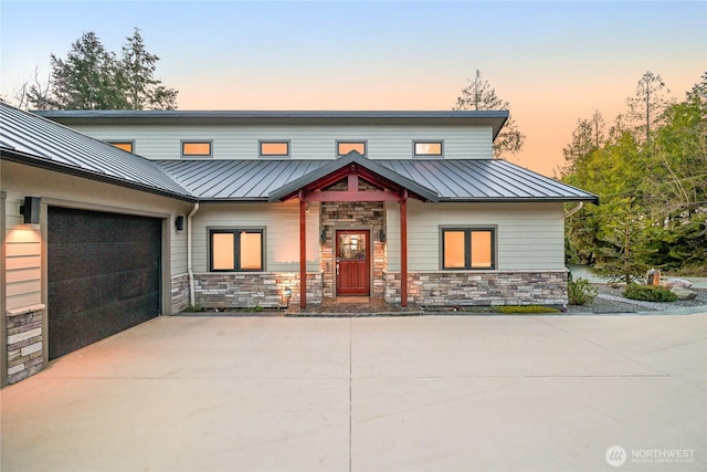 229 Chuckanut Point Rd, Bellingham, WA 98229 - view of front facade featuring a standing seam roof, concrete driveway, a metal roof, a garage, and stone siding
