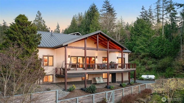 229 Chuckanut Point Rd, Bellingham, WA 98229 - back of house at dusk featuring a standing seam roof, a metal roof, and a wooden deck