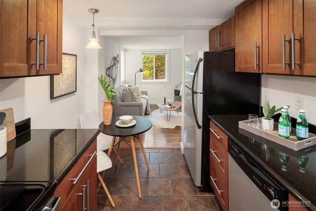 9013 16th Ave SW Unit 11, Seattle, WA 98106 - kitchen featuring appliances with stainless steel finishes, brown cabinetry, stone tile flooring, and decorative light fixtures