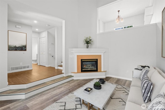 8629 240th St SW Unit B4, Edmonds, WA 98026 - living room featuring wood finished floors, a chandelier, a glass covered fireplace, and recessed lighting