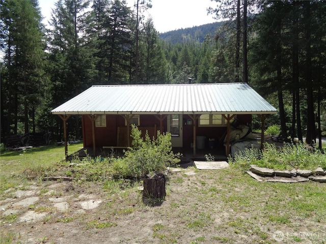 270 W Fork Rd, Conconully, WA 98819 - view of front facade featuring a forest view, covered porch, a metal roof, and a front lawn