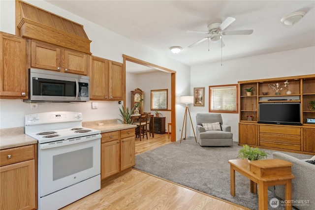 30 E Richardson Rd, Belfair, WA 98528 - kitchen featuring stainless steel microwave, white range with electric cooktop, light wood finished floors, a ceiling fan, and light countertops