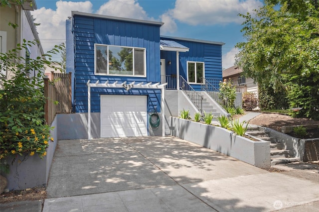 5253 35th Ave SW, Seattle, WA 98126 - contemporary house featuring stairway, board and batten siding, concrete driveway, and an attached garage