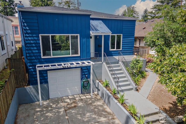 5253 35th Ave SW, Seattle, WA 98126 - view of front of house featuring an attached garage, concrete driveway, board and batten siding, roof with shingles, and stairs