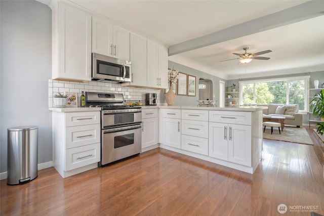 5253 35th Ave SW, Seattle, WA 98126 - kitchen with appliances with stainless steel finishes, a peninsula, open floor plan, light countertops, and light wood-style flooring