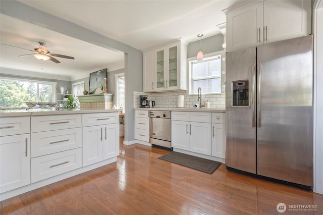 5253 35th Ave SW, Seattle, WA 98126 - kitchen with appliances with stainless steel finishes, decorative backsplash, light countertops, ceiling fan, and glass insert cabinets