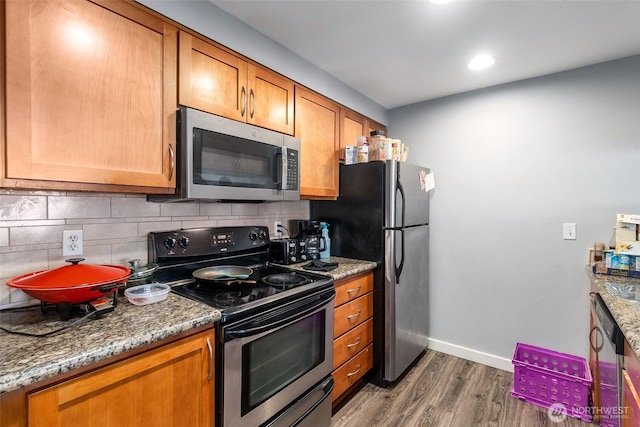 25 N Broadway Unit 207, Tacoma, WA 98403 - kitchen with appliances with stainless steel finishes, dark wood finished floors, decorative backsplash, brown cabinets, and recessed lighting