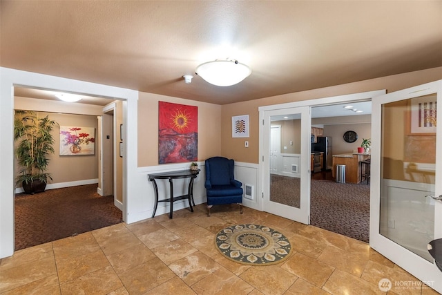 25 N Broadway Unit 207, Tacoma, WA 98403 - sitting room with light colored carpet, french doors, light stone finish floors, and wainscoting
