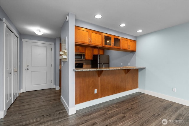 25 N Broadway Unit 207, Tacoma, WA 98403 - kitchen with freestanding refrigerator, brown cabinetry, stainless steel microwave, glass insert cabinets, and dark wood-style flooring