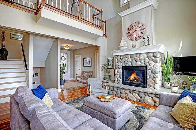 656 Lehman Dr, Camano Island, WA 98282 - living room with wood finished floors, a high ceiling, a fireplace, and stairway