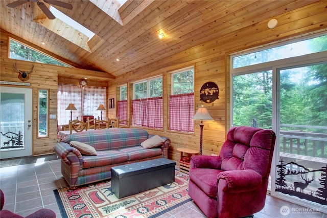 44664 Similk Trl, Concrete, WA 98237 - tiled living room featuring plenty of natural light, a ceiling fan, wooden walls, a skylight, and wood ceiling