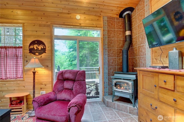 44664 Similk Trl, Concrete, WA 98237 - sitting room featuring a wood stove, wood walls, and tile patterned flooring
