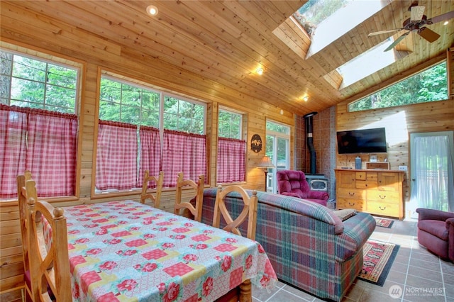 44664 Similk Trl, Concrete, WA 98237 - dining room featuring a wood stove, wood walls, high vaulted ceiling, a skylight, and a ceiling fan