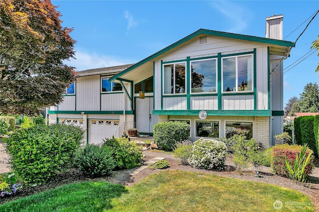 1728 N James St, Tacoma, WA 98406 - split foyer home with an attached garage, a chimney, and brick siding