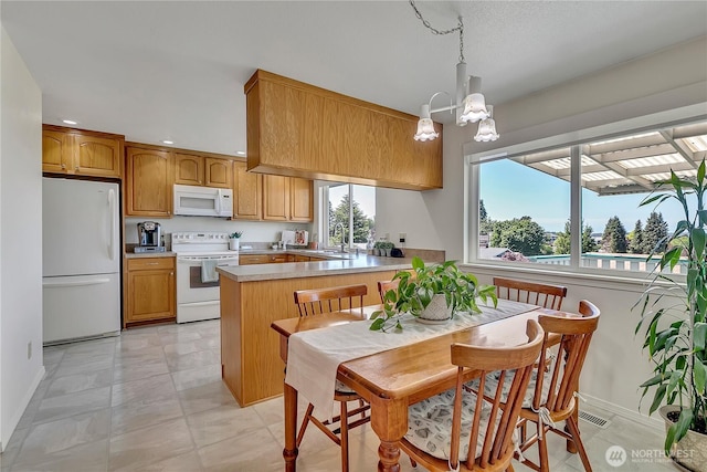 1728 N James St, Tacoma, WA 98406 - kitchen with white appliances, a peninsula, a chandelier, recessed lighting, and light countertops