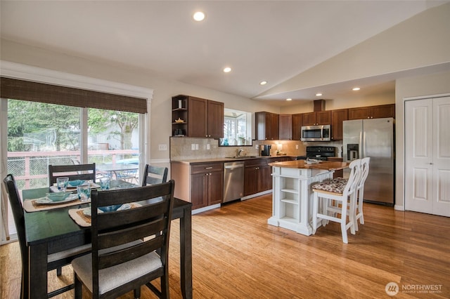 755 Island Cir SE, Ocean Shores, WA 98569 - kitchen with appliances with stainless steel finishes, open shelves, tasteful backsplash, lofted ceiling, and a center island