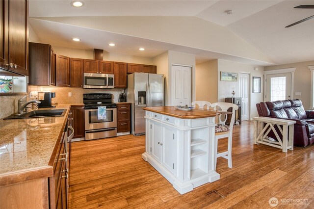755 Island Cir SE, Ocean Shores, WA 98569 - kitchen featuring stainless steel appliances, lofted ceiling, open floor plan, light wood-style flooring, and decorative backsplash