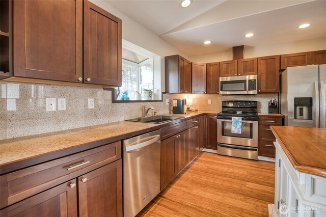 755 Island Cir SE, Ocean Shores, WA 98569 - kitchen with stainless steel appliances, lofted ceiling, light wood-style floors, decorative backsplash, and recessed lighting