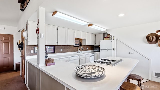 767 Bill Shaw Rd, Pateros, WA 98846 - kitchen with white appliances, a kitchen bar, light countertops, white cabinetry, and tasteful backsplash