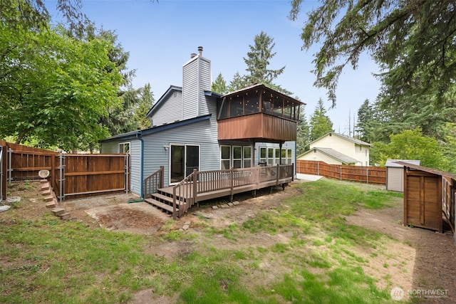 8037 Incline Dr SE, Olympia, WA 98513 - rear view of house with a deck, a fenced backyard, a chimney, and a storage unit