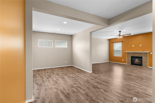 18328 73rd Avenue Ct E, Puyallup, WA 98375 - unfurnished living room with wood finished floors, healthy amount of natural light, a tiled fireplace, a ceiling fan, and recessed lighting