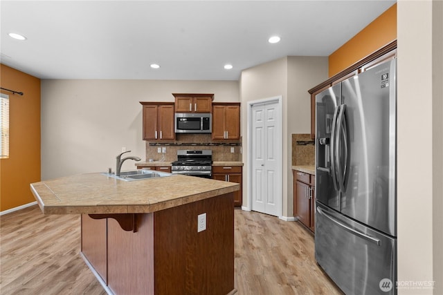 18328 73rd Avenue Ct E, Puyallup, WA 98375 - kitchen with appliances with stainless steel finishes, light wood finished floors, tasteful backsplash, a kitchen breakfast bar, and recessed lighting
