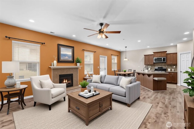 18328 73rd Avenue Ct E, Puyallup, WA 98375 - living area with recessed lighting, light wood-style floors, a ceiling fan, and a glass covered fireplace