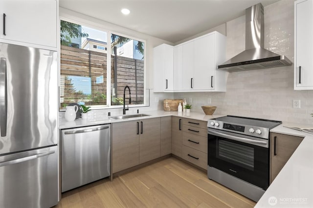 1313 14th Ave S Unit B, Seattle, WA 98144 - kitchen with wall chimney range hood, appliances with stainless steel finishes, light countertops, light wood finished floors, and decorative backsplash