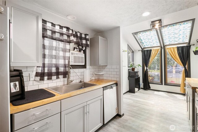 9307 Albert Way SE, Moses Lake, WA 98837 - kitchen featuring stainless steel dishwasher, a textured ceiling, tasteful backsplash, light wood finished floors, and recessed lighting
