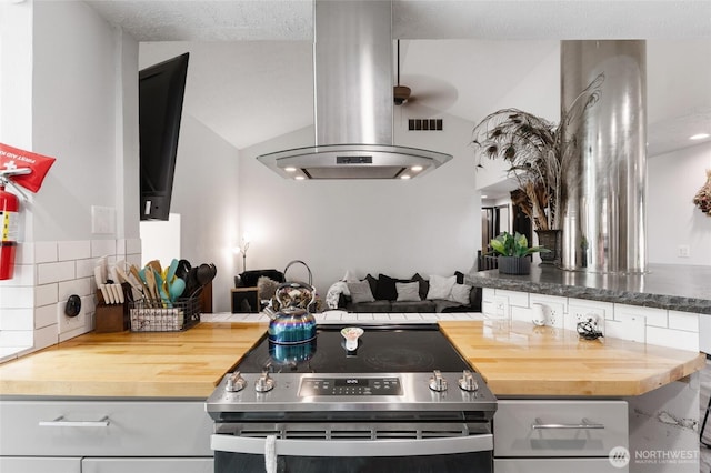 9307 Albert Way SE, Moses Lake, WA 98837 - kitchen with stainless steel electric range oven, island exhaust hood, butcher block countertops, vaulted ceiling, and decorative backsplash