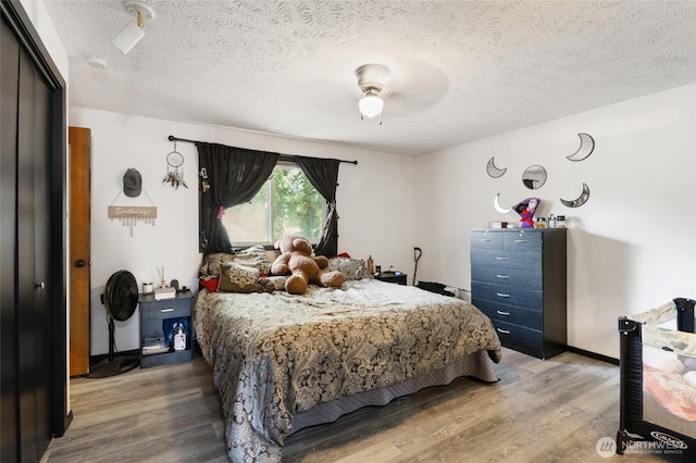 9307 Albert Way SE, Moses Lake, WA 98837 - bedroom featuring light wood-style flooring, a textured ceiling, ceiling fan, and a closet