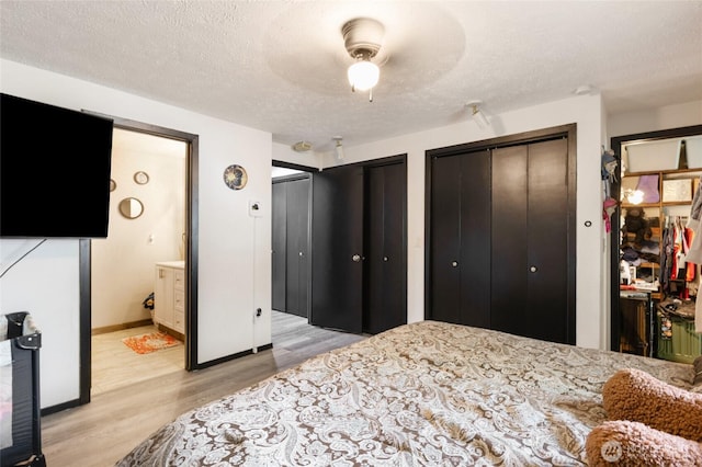 9307 Albert Way SE, Moses Lake, WA 98837 - bedroom featuring light wood-style floors, a textured ceiling, two closets, and ensuite bathroom