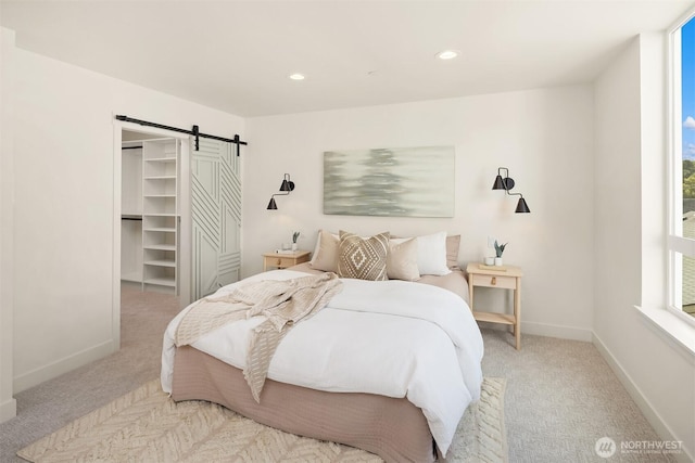 1615 N 50th St Unit B, Seattle, WA 98103 - bedroom featuring a barn door, light carpet, a spacious closet, and recessed lighting